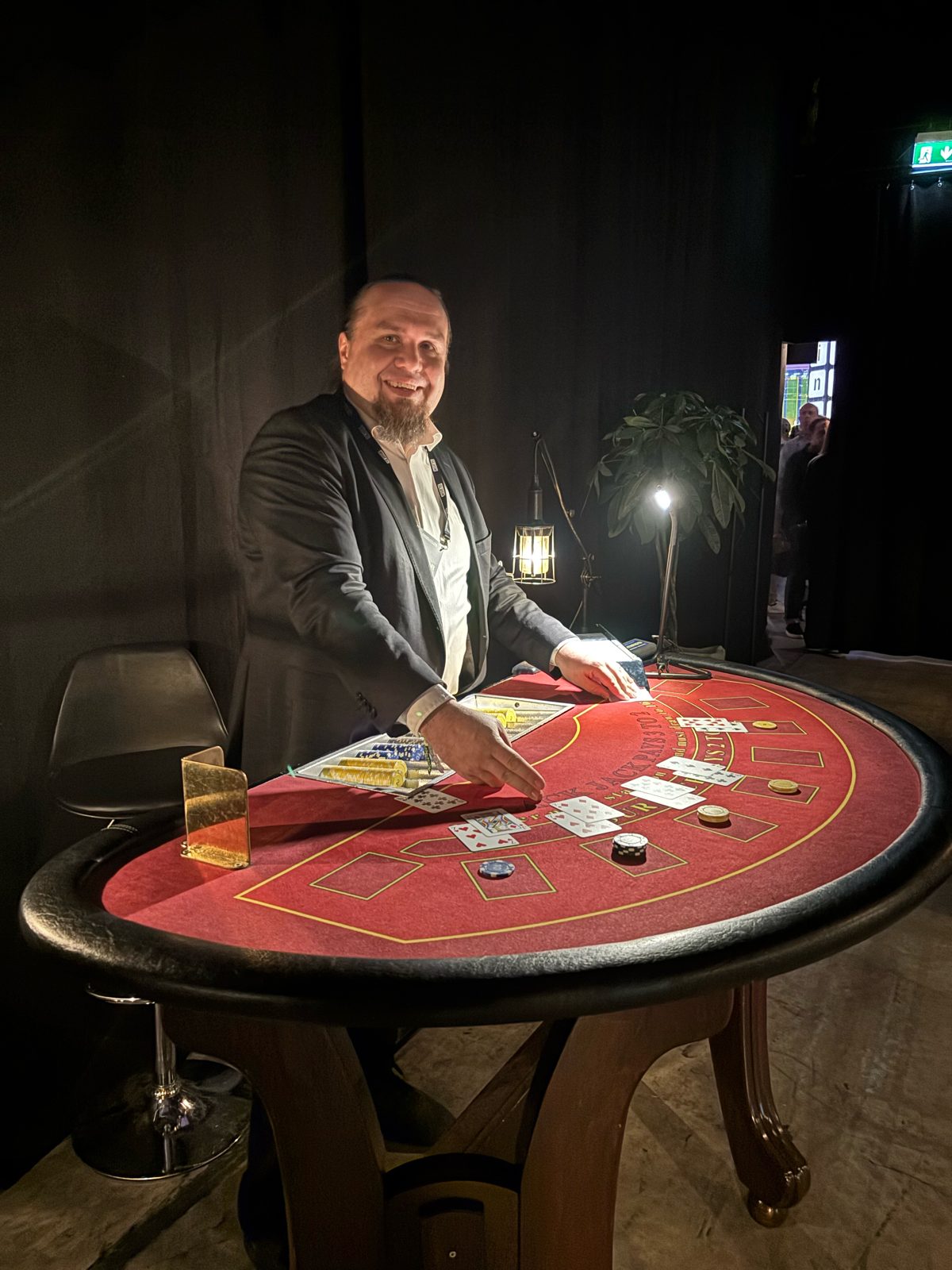 Pelinhoitaja jakaa kortteja punaisella blackjack-pöydällä